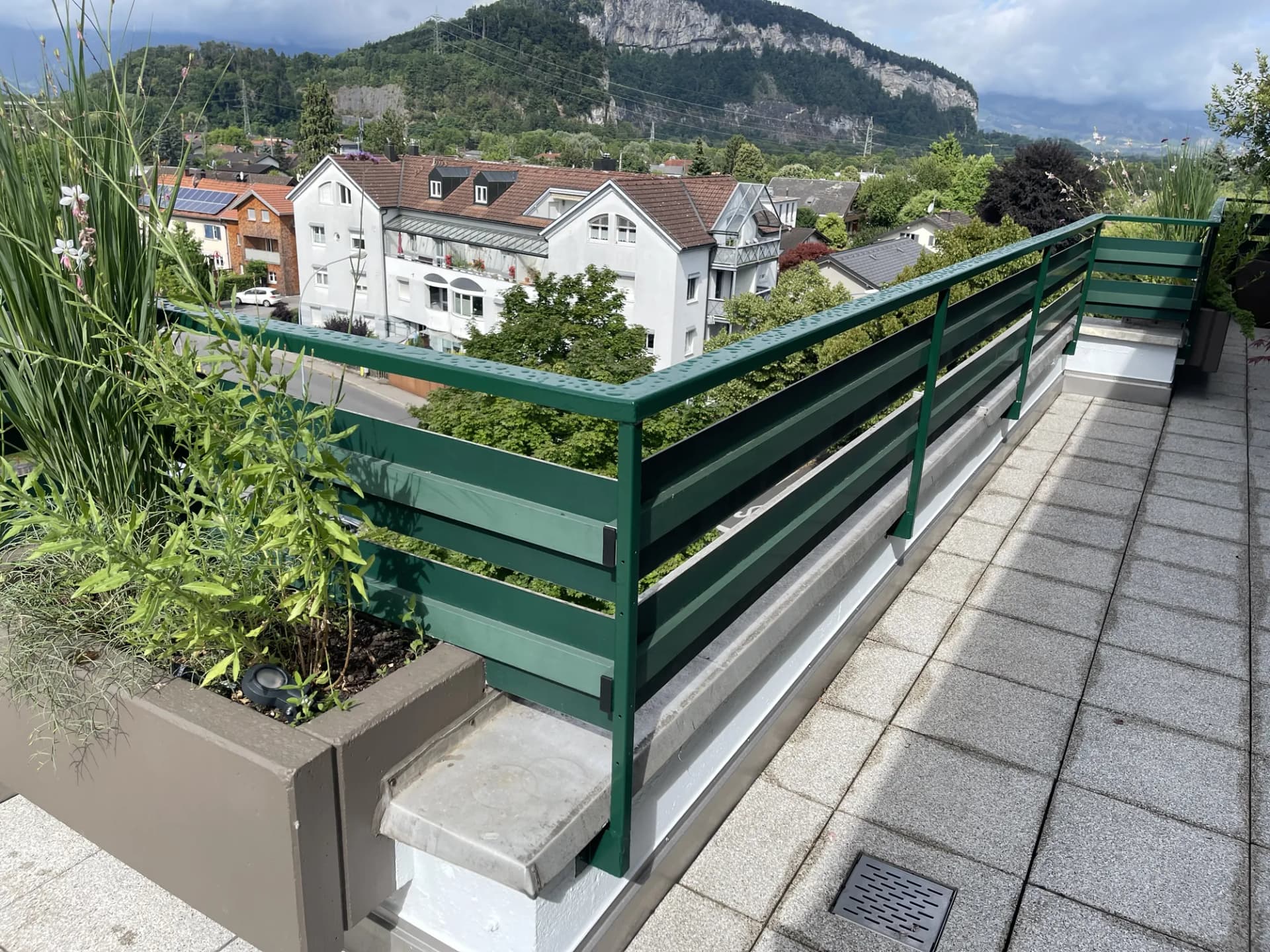 Grün lackiertes Geländer auf einer Dachterrasse